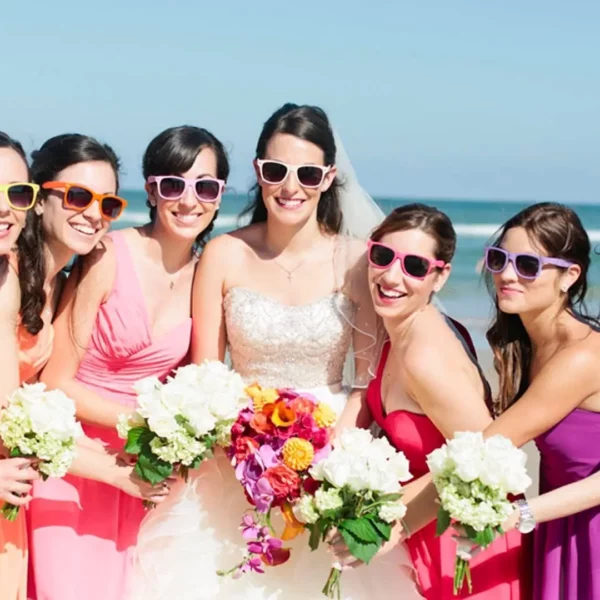 bride and bridal party on the beach with sunglasses on at beautiful oceanfront Plaza Resort & Spa in Daytona Beach Florida