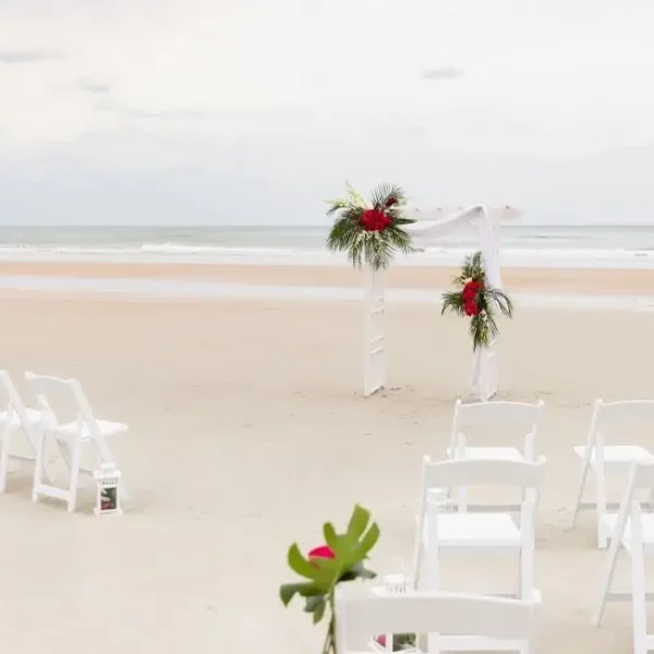 wedding altar decorated with palms and rows of ceremony seating chairs on the beach at beautiful oceanfront Plaza Resort & Spa in Daytona Beach Florida