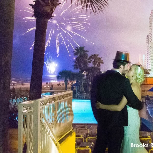 bride and groom sharing a kiss next to the pool at beautiful oceanfront Plaza Resort & Spa in Daytona Beach Florida