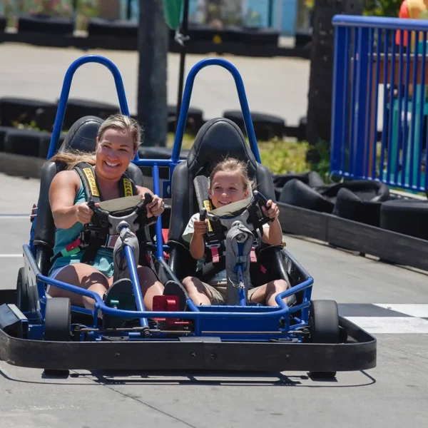 fun mom and young daughter driving a double seater gocart